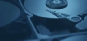 Blurred image of a hard drive focusing on its internal components, illustrating our IT asset disposition (ITAD) services focused on data security and responsible recycling.